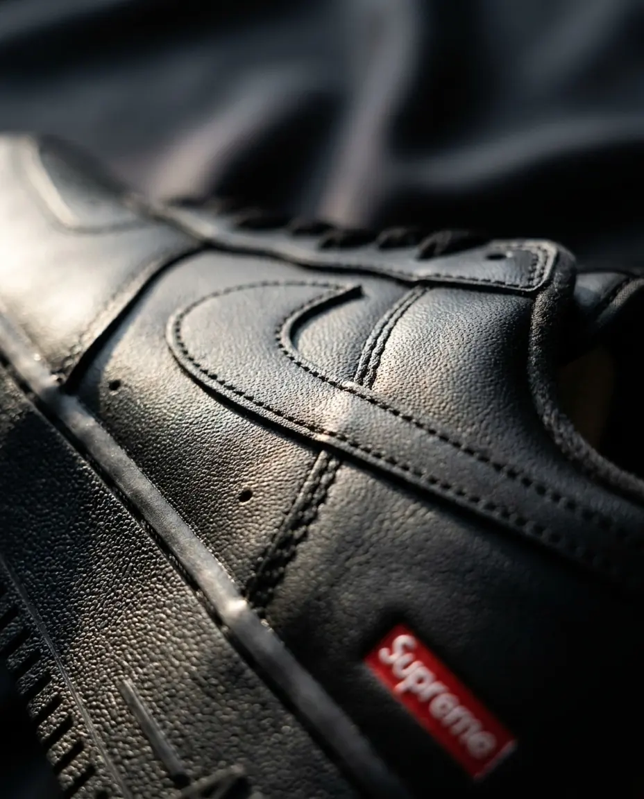 Macro photograph of black sneaker leather and a red Supreme label